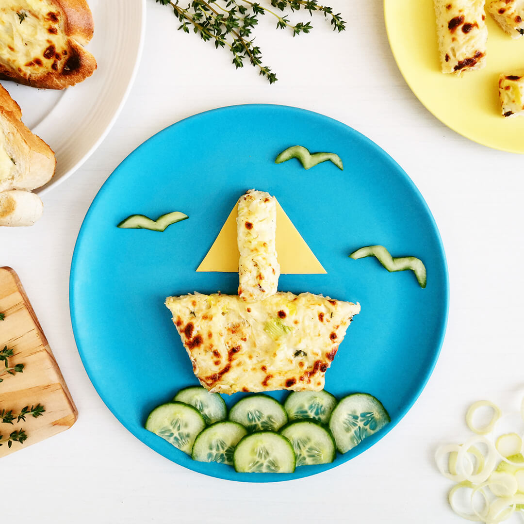 Really Welsh Rarebit on a plate shaped to look like a boat on cucumber slice waves with cucumber shaped birds