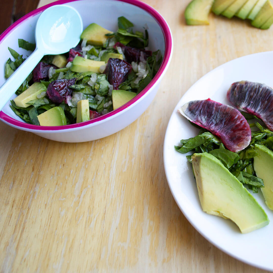 A serving of Blood Orange & Avocado Salad, next to a bowl of Blood Orange & Avocado Salad