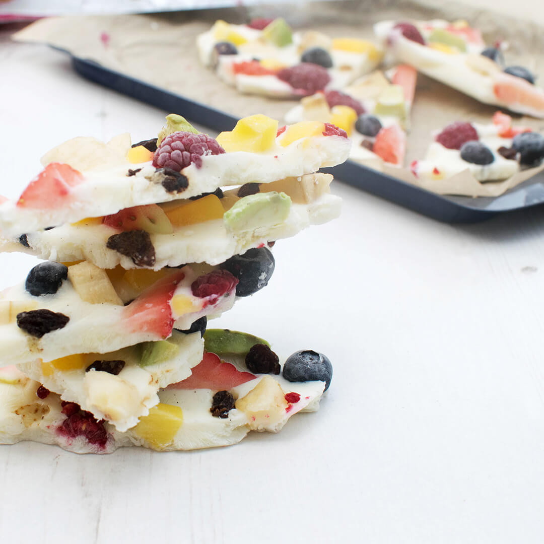 A stack of fruity yoghurt bites, next to a tray of yoghurt bites