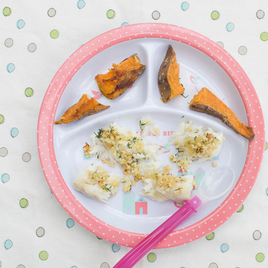 A plate of fish served with sweet potato fries