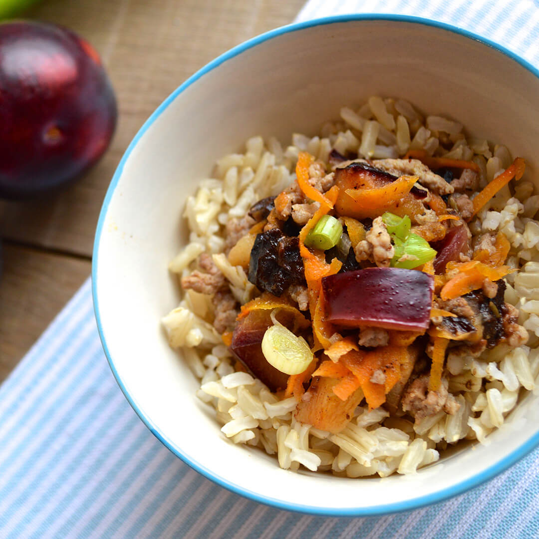 A bowl of Spiced Pork With Plum served with rice