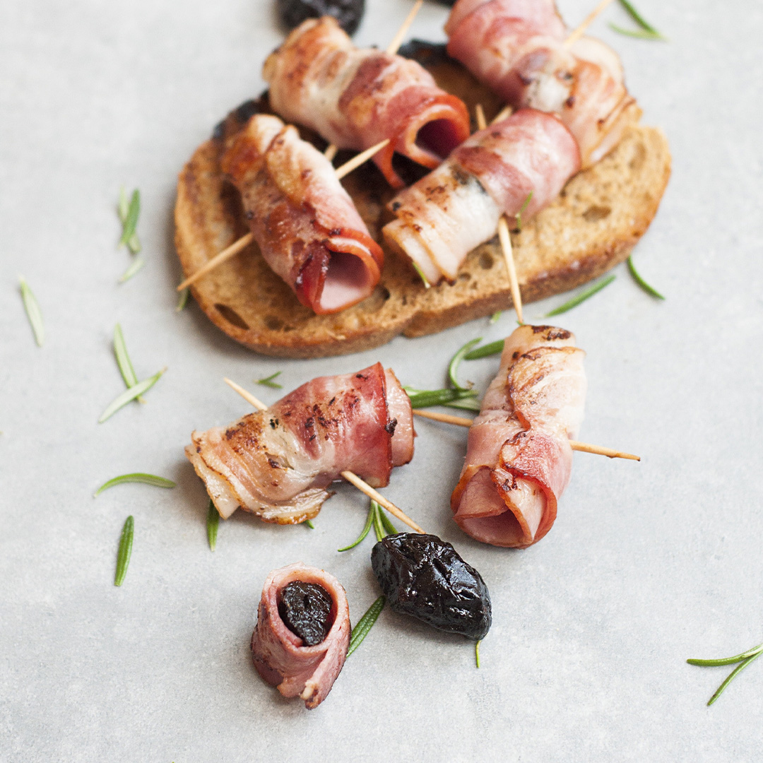 Some rolls of bacon/meat with cocktail sticks through them