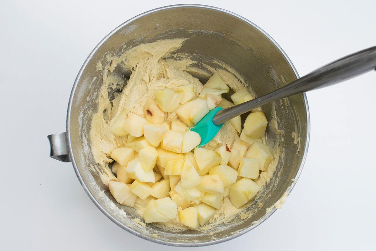 Apple cubes being folded into the cake batter