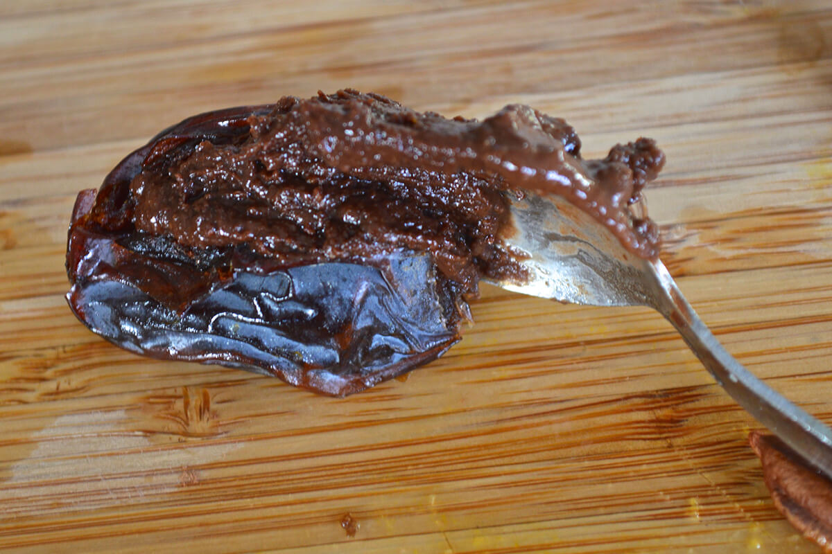 A sliced date being filled with chocolate orange mixture