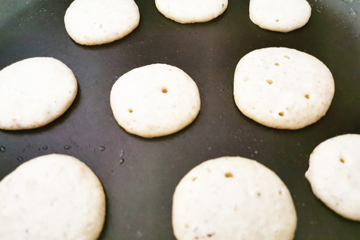 Mini pancakes being cooked in a pan