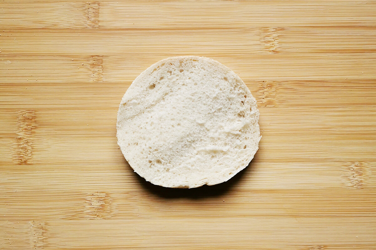 A halved English muffin on a chopping board