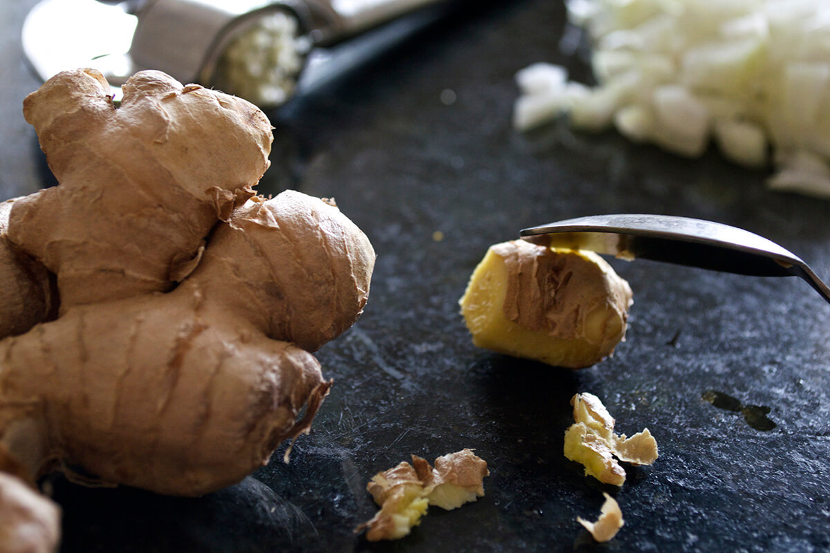 A chopping board with finely chopped onion and garlic root