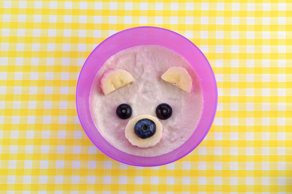 Blueberry half placed on banana circle to create nose