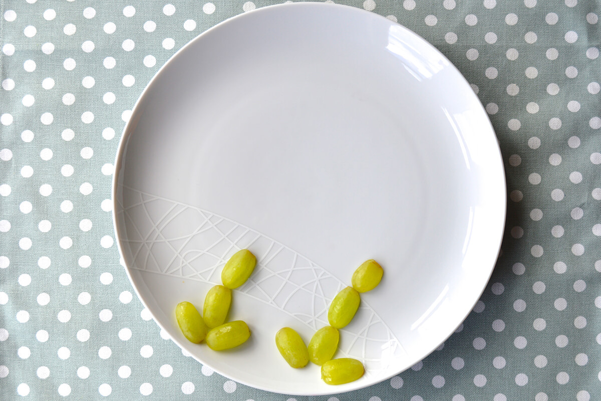 Halved grapes placed on plate creating flower stems