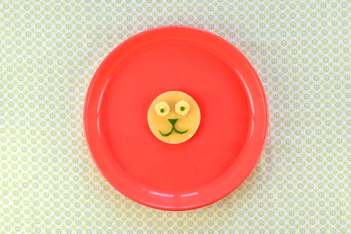 Baby corn slices added to cheese circle and topped with tiny cucumber circles to make eyes