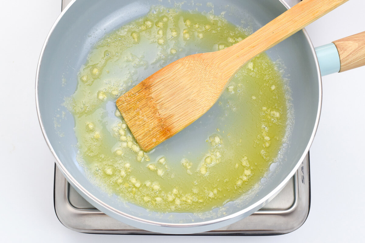 A pan of crushed garlic being softened in butter