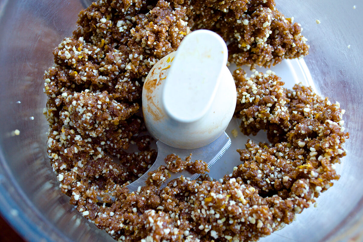 Nuts, dates, orange zest and spice being blended in a food processor