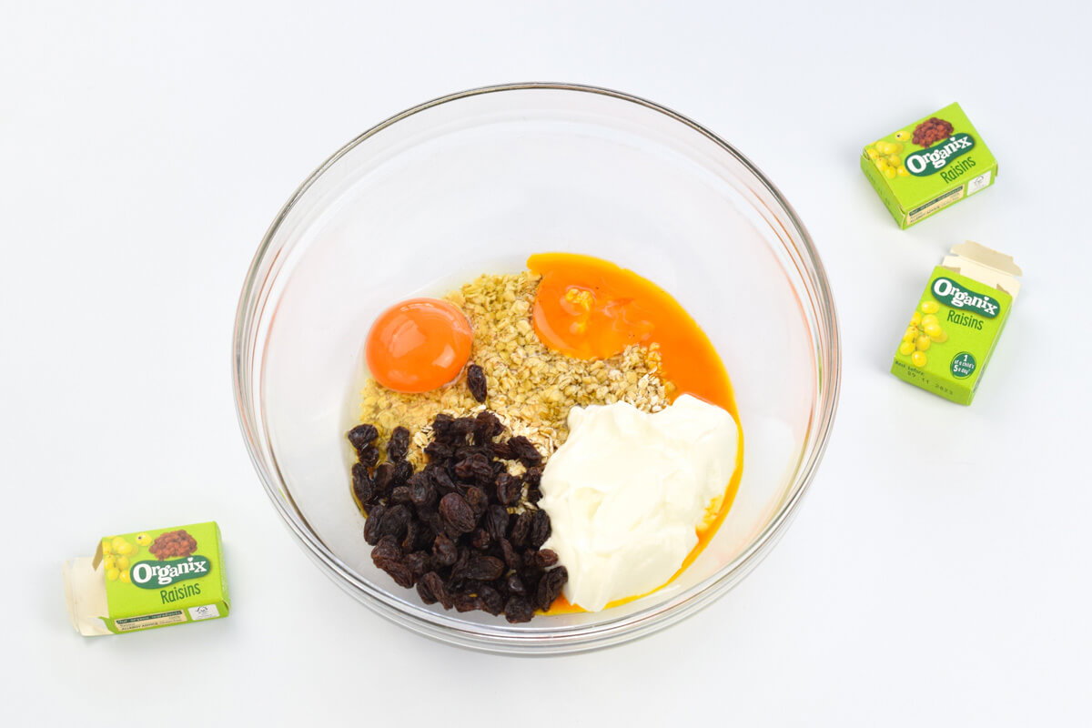 A large lass bowl with oats, raisins, eggs and yoghurt