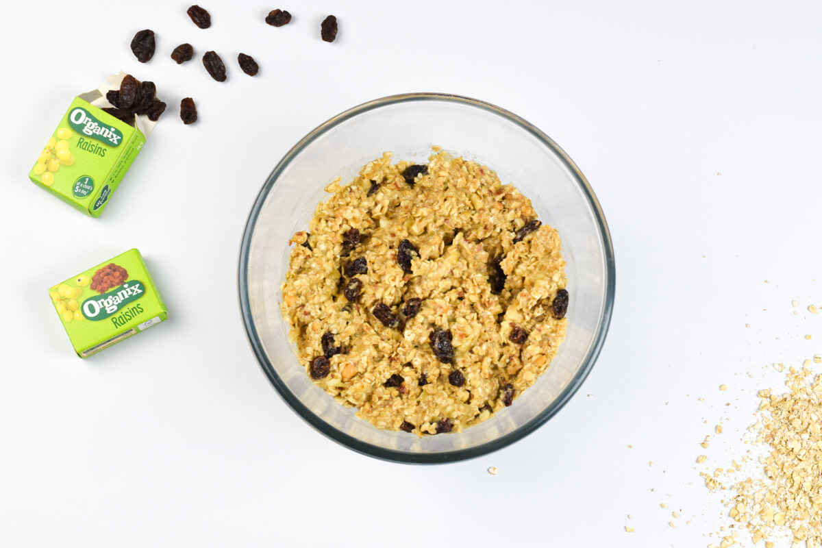 A glass bowl with peanut butter raisin cookie mix